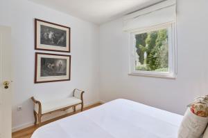 a white room with a bed and a window at Casa da Lameira in São Lourenço