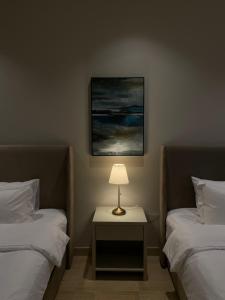 1 dormitorio con 2 camas y mesa con lámpara en Elite Resort - Private Pool & Beach, en Bahía de la Media Luna
