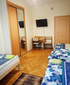 a room with two beds and a table and a mirror at Ratuszowy in Włocławek