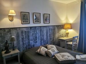 een slaapkamer met een bed en wat foto's aan de muur bij Les Tamaris in Campsegret