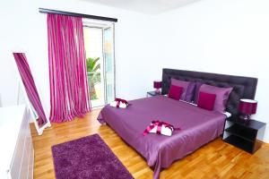 Un dormitorio con una gran cama púrpura con almohadas rosas en Royal Deluxe, en Split