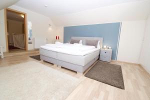 a large white bedroom with a large white bed at Sonnenwind am Norddeich in Norddeich