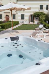 un jacuzzi en un patio con sombrilla en Madonna Villa Baietta, en Verona