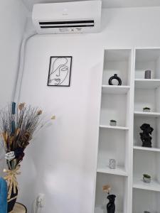 sala de estar blanca con ventilador de techo en Monica Studio, en Onești