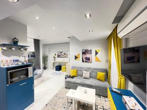ein Wohnzimmer mit einem grauen Sofa und gelben Akzenten in der Unterkunft Luxury Studio House 589-5 in Madinat as-Sadis min Uktubar