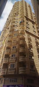 ein hohes Gebäude mit Balkon an der Seite in der Unterkunft Air-conditioned apartment - شقة مكيفه للايجار ف ميامي in Alexandria