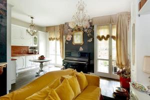 a living room with a yellow couch and a kitchen at Luxe Garden Apt for 2nr Bologna in Casalecchio di Reno