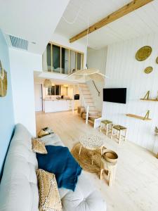 un soggiorno con divano bianco e tavolo di Les Voiles - Appart'hotel "Le Sein" a Carnac