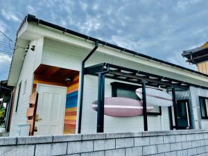 uma casa com um barco cor-de-rosa ao lado dela em うみいろキャビン 
