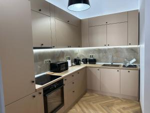 a kitchen with white cabinets and a sink at Oyster Flat Victoriei in Bucharest