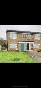 a brick house with a green lawn in front of it at Cosy flat in Little Paxton