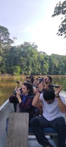 un groupe de personnes prenant des photos d'une rivière dans l'établissement WaitaAmazonlodge, 