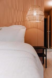 - une chambre avec un lit blanc et une lampe dans l'établissement Chimay : La Chambre Dorée de la Grand Place, à Chimay