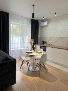 uma cozinha com mesa e cadeiras num quarto em Apart Inn - Апарт Отель em Oral