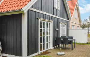 una casa negra con una mesa delante en Blvandslyst, en Blåvand