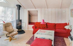 sala de estar con sofá rojo y chimenea en Cozy Home In Sby With Wifi en Nordost
