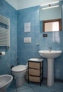 baño de azulejos azules con lavabo y aseo en Pura Vida, en Roma