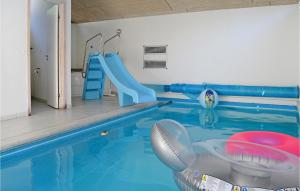 a indoor swimming pool with a slide and a slide at Awesome Home In Jerup With Indoor Swimming Pool in Jerup