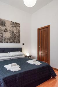 Un dormitorio con una cama azul con toallas. en Pura Vida, en Roma