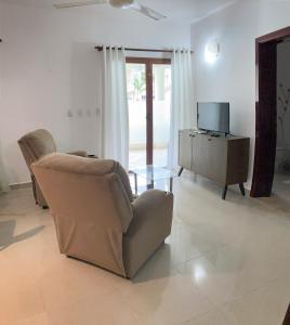 ein Wohnzimmer mit einem Stuhl und einem TV in der Unterkunft OKAINA 2 in Cabarete