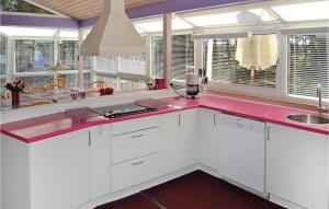 una cucina con armadi bianchi e ripiano rosa di Awesome Home In Jerup With Indoor Swimming Pool a Jerup