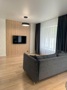 a living room with a couch and a flat screen tv at Apart Inn - Апарт Отель in Uralsk