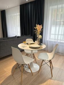 - une table et des chaises blanches dans le salon dans l'établissement Apart Inn - Апарт Отель, à Uralsk