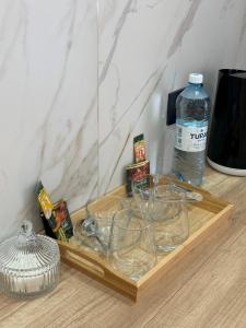 a wooden tray with glasses and a bottle of water at Apart Inn - Апарт Отель in Uralsk