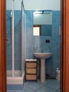 y baño de azulejos azules con lavabo y ducha. en Pura Vida, en Roma