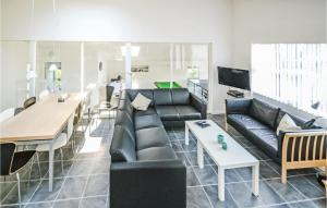 sala de estar con sofá negro y mesa en Nice Home In Hvide Sande With Kitchen en Hvide Sande