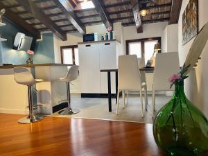una cocina con mesa y sillas y un jarrón con flores en StaraGo Apartment, en Gorizia