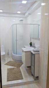 La salle de bains blanche est pourvue d'un lavabo et d'une baignoire. dans l'établissement Damaris Apartments, à Chişinău