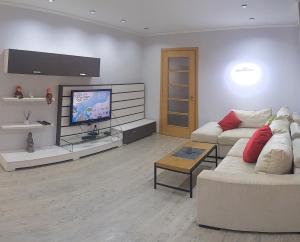 un salon avec deux canapés et une télévision à écran plat dans l'établissement Damaris Apartments, à Chişinău