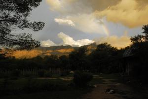 a rainbow in the sky over a mountain at TrinidadTraslasierra in Las Rabonas