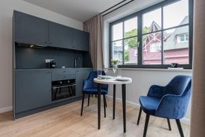 una cucina con tavolo, due sedie blu e un tavolo di Gustav Appartements a Binz