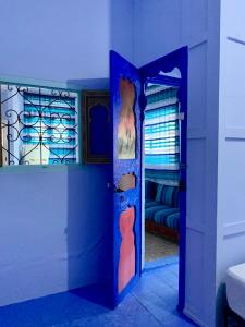 a blue room with a door and a bedroom at Dar Besmellah in Chefchaouen