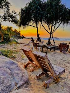 a picnic table and chairs on a beach at Sarada Beach Resort Yala in Tissamaharama