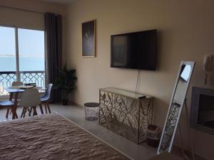 a living room with a bed and a television on the wall at Dream studio panoramic beach and sea view in Ras al Khaimah