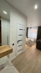 a room with a door and a living room with a table at Apart Inn - Апарт Отель in Uralsk