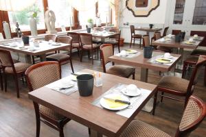 a dining room with wooden tables and chairs at Hotel Geromont in Andernach