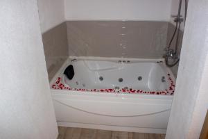 a white bath tub with red roses around it at Aloha Suites in Marmaris