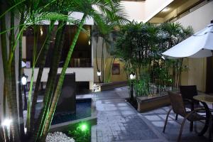un patio con mesa y plantas en un edificio en Cedro Hotel, en Londrina