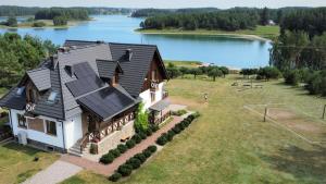 uma vista aérea de uma casa ao lado de um lago em Wyspa Kaszubska dom wypoczynkowy z sauną i balią em Lipnica