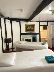 a bedroom with two beds and a fireplace at The King's Lodge Hotel in Kings Langley