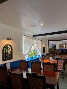 a dining room with tables and chairs and a window at The King's Lodge Hotel in Kings Langley