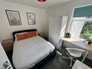 a bedroom with a bed and a desk and a window at Littlehampton House - 4 bedroom house sleeps 8 in Littlehampton