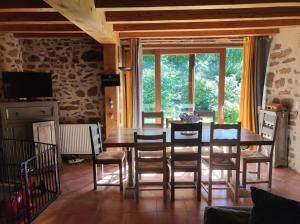 a dining room with a wooden table and chairs at Gite du Dolmen classé 3 épis in Blessac