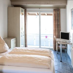 a bedroom with a bed and a desk with a computer at Landhotel Bodensee in Konstanz