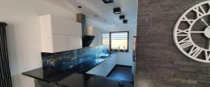 a kitchen with a black counter and a brick wall at Apartament Wiedeński in Bielsko-Biała