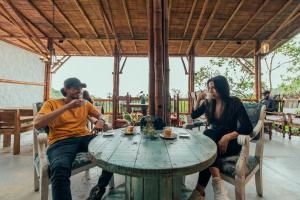 dwoje ludzi siedzących przy stole jedzących jedzenie w obiekcie La Cabaña - Monte Jazmín w mieście Pereira